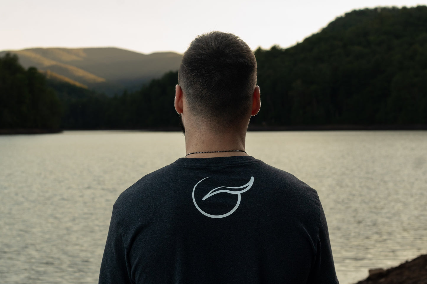 View of the Upper Shoulders of the Black Balance Short Sleeve 50/50 Up-Cycled Cotton Recycled Polyester Blended T Shirt  With the Breath Emblem Between the Shoulder Blades.