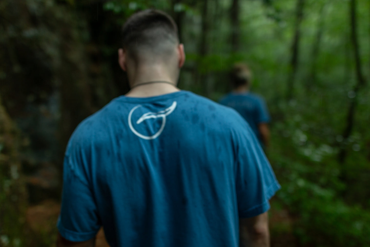 Back of light blue t shirt made from 100% Organic Cotton displaying the Breath brand name across the front with the logo on the back.