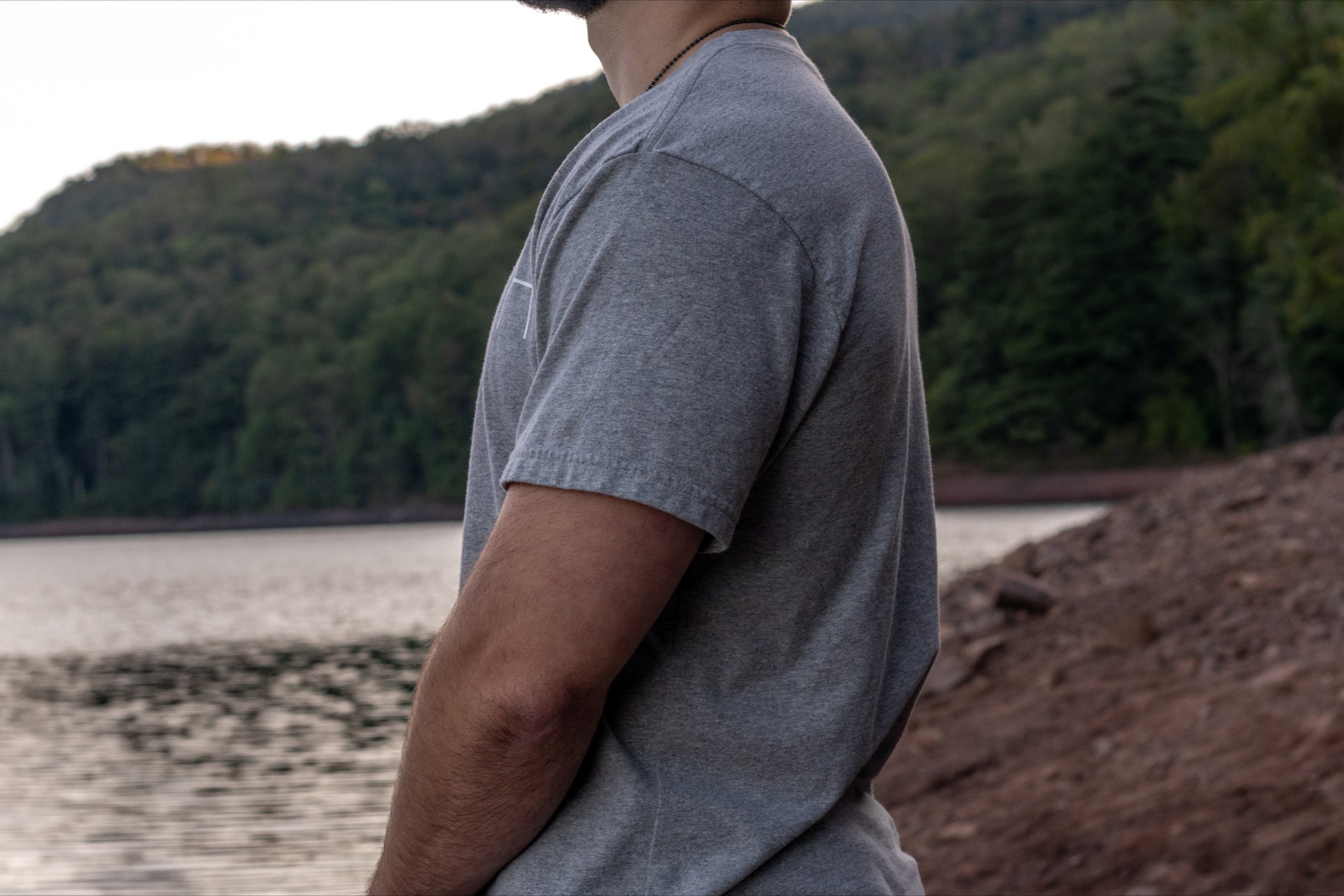 displaying the drape of the 50/50 upcycled cotton and recycled polyester short sleeve t shirt in grey.
