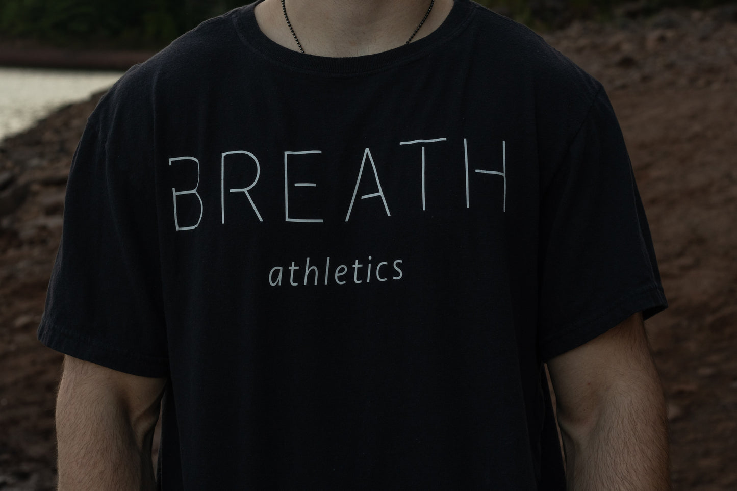 Front View of a Black Short Sleeve Organic Cotton T Shirt with Breath Across the Chest.