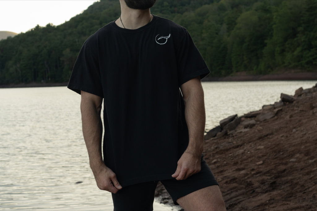 the front of the 100% Organic cotton black  t shirt by Breath with the logo on the left chest and the brand name across the back.