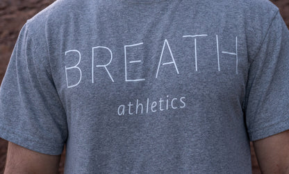 Close up shot of the front of the 50/50 recycled cotton polyester blended grey t-shirt by Breath with Breath across the chest.