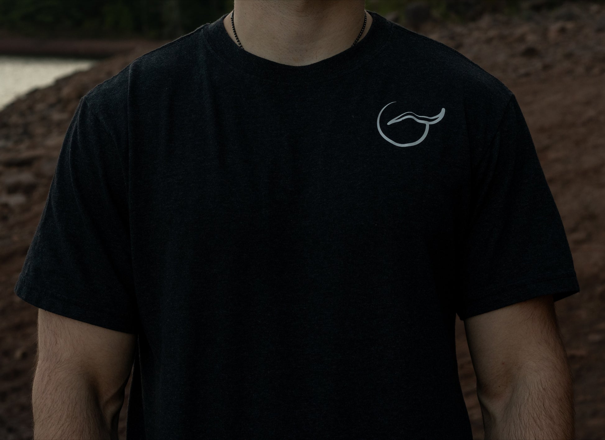 chest view of the Organic cotton black t shirt with short sleeves with the logo on the left chest.