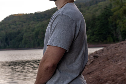 displaying the drape of the 50/50 upcycled cotton and recycled polyester short sleeve t shirt in grey.