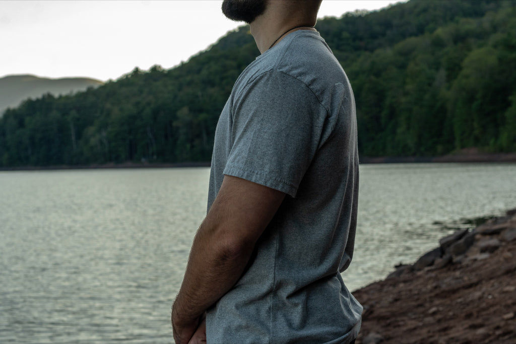 Side view of a grey short sleeve t shirt made from 50/50 recycled cotton and polyester.