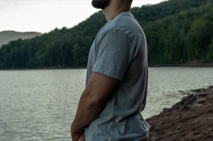 Side view of a grey short sleeve t shirt made from 50/50 recycled cotton and polyester.
